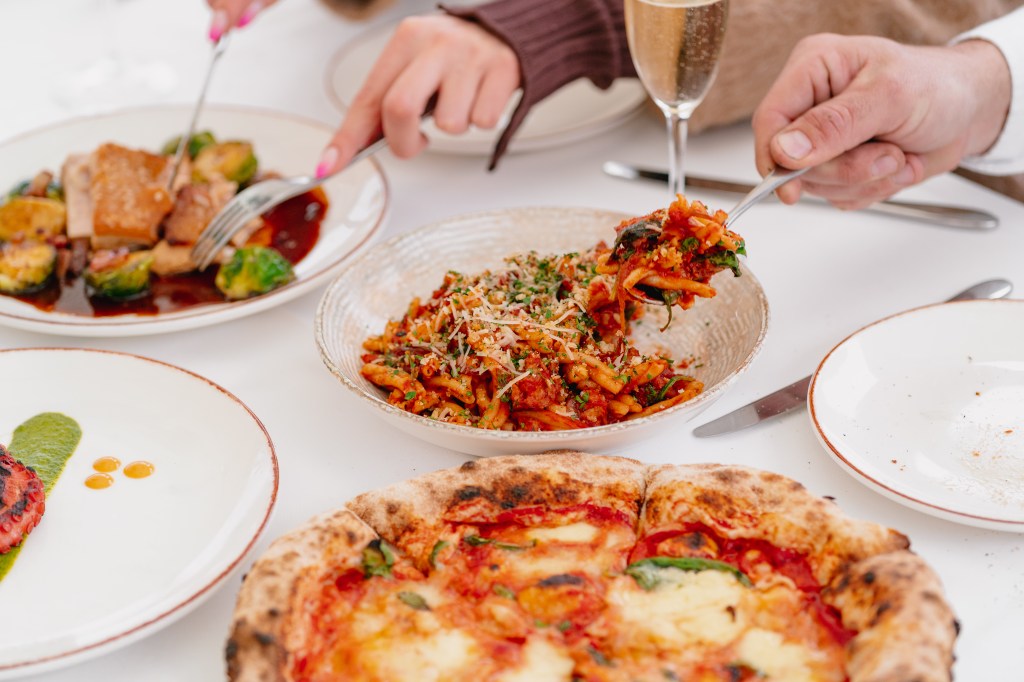 Close-up dishes of pizza and pasta.