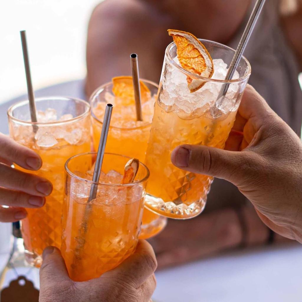 Close-up of hands holding cocktail glasses.