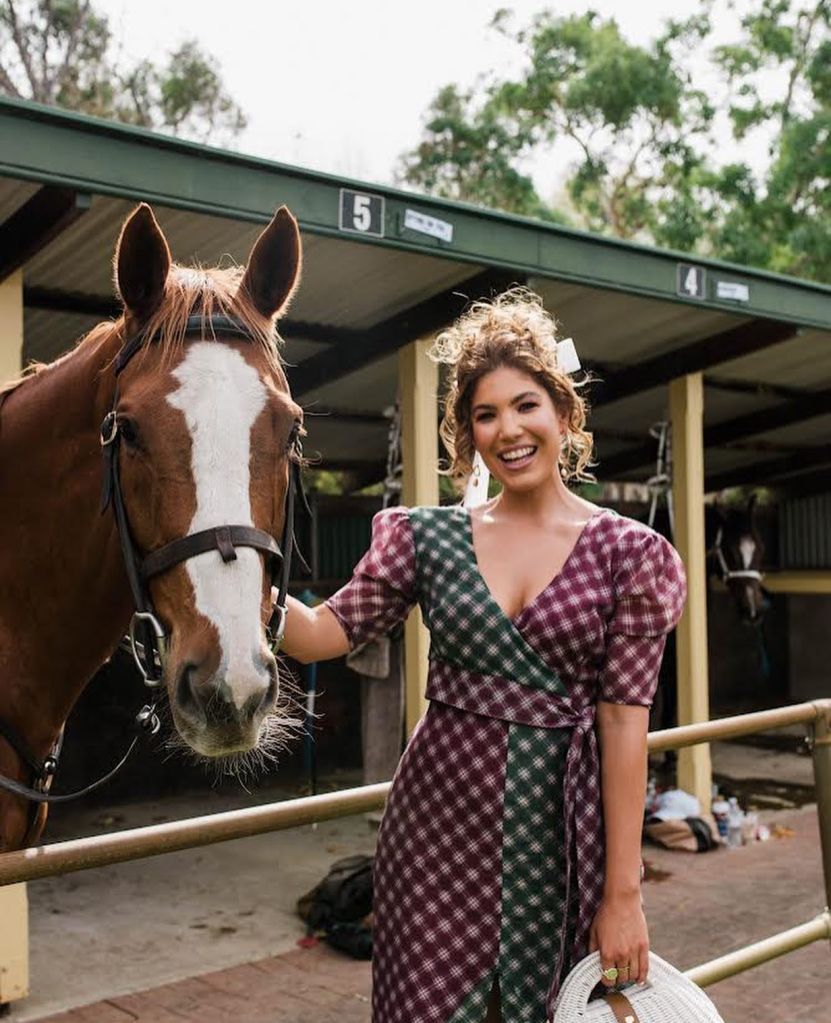Adelaide stylish, Lauren Dilena, poses in a racing dress beside a horse.