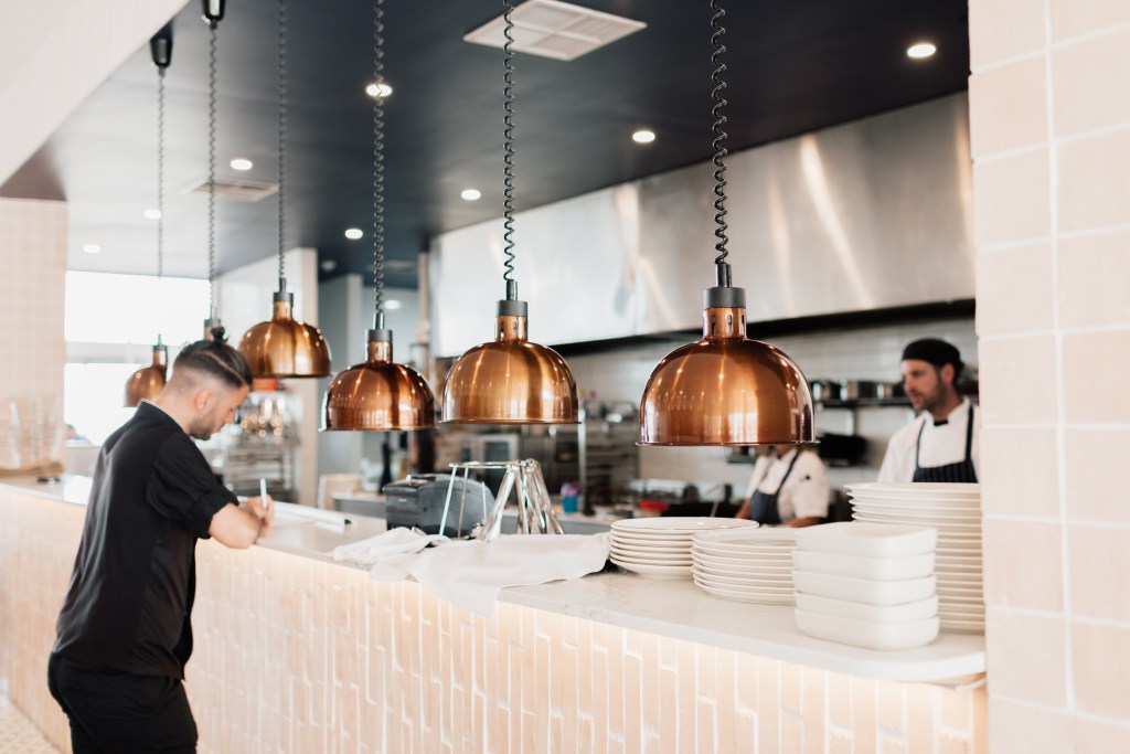 Wait staff writes on a piece of bar at Luciano's On The Marina bar.