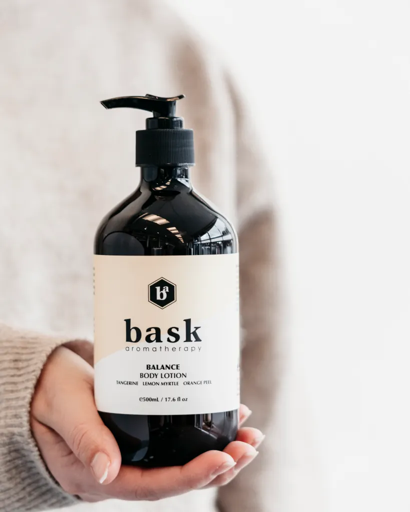 Bottle of body lotion with Bask Aromatherapy branding.